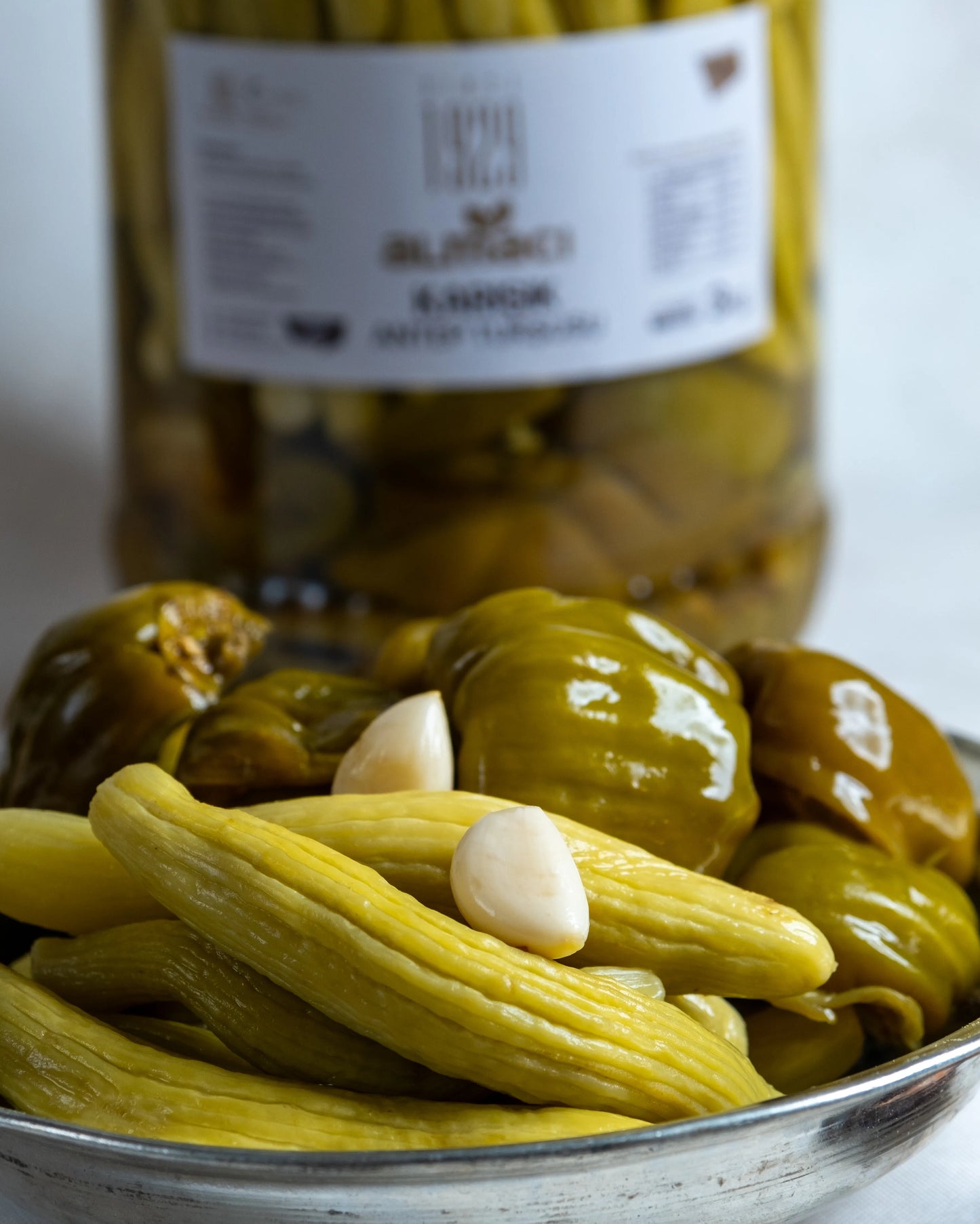 Almacı Pazarı 3kg karışık turşu bidonu ve sunum tabağı; içinde sadece acur ve biber bulunan, sarımsaklı ve sirkeli geleneksel Antep turşusu.