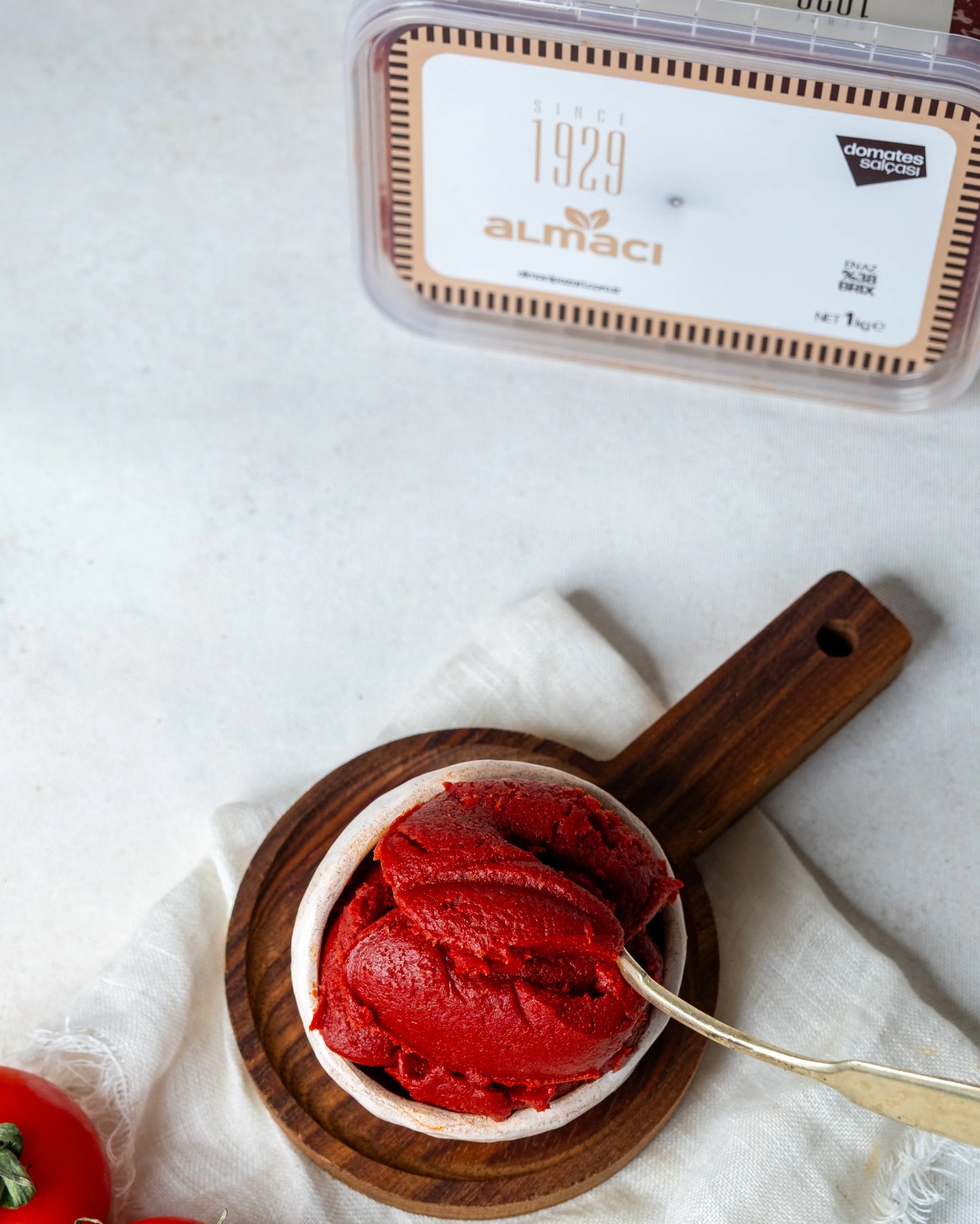 Yakından görünüm kasede domates salçası, kaşıkta iz bırakan yoğun kıvamı ve parlak kırmızı rengiyle güneşte kurutulmuş doğal lezzet.