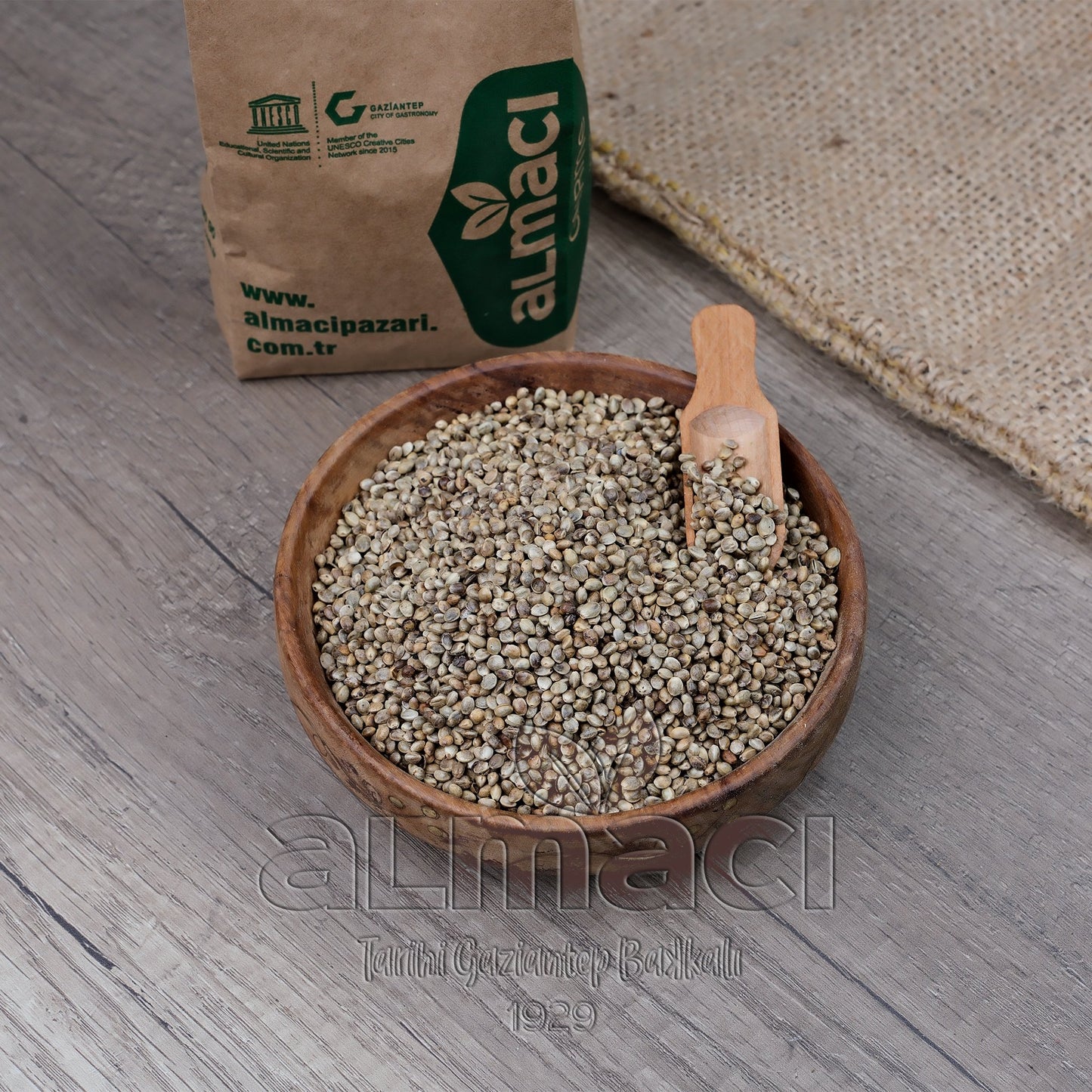 Ahşap bir kasede kavrulmuş kendir tohumu, küçük ahşap kaşıkla birlikte duruyor.