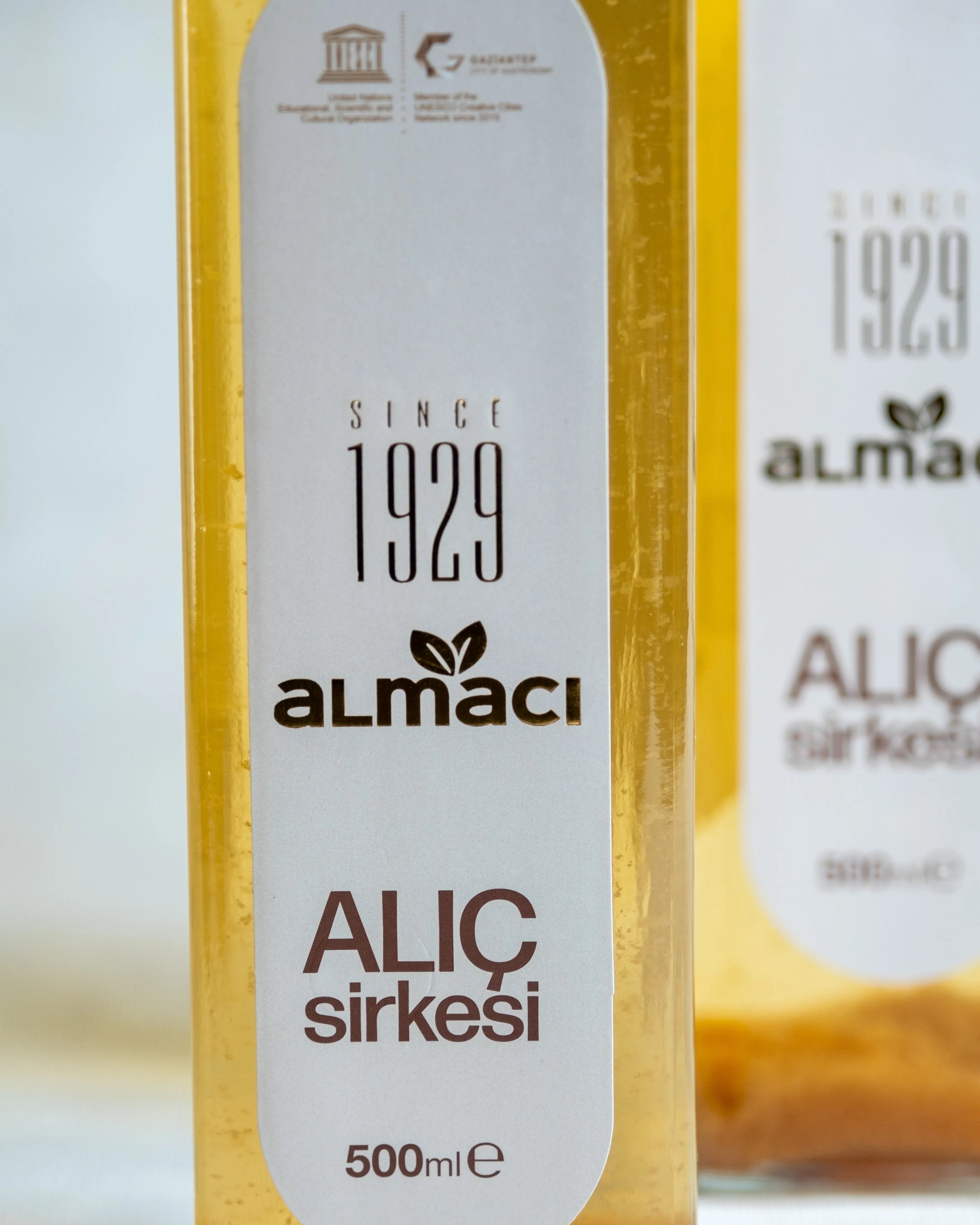 Almacı Pazarı alıç sirkesi yakın çekim; 500 ml cam şişede sirke anası ve doğal tortusu görünen geleneksel fermente alıç sirkesi.