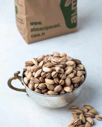 Yakından görünüm metal kasede Antep fıstığı, dalında kendiliğinden açılan ana çıtlak, az tuzlu ve çifte kavrulmuş taze mahsül.