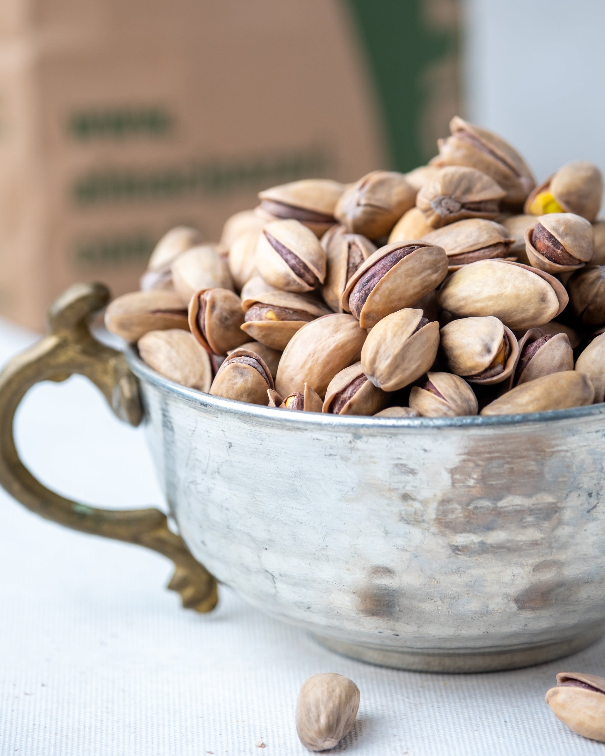 Yakından görünüm metal kasede Antep fıstığı, dalında kendiliğinden açılan ana çıtlak, az tuzlu ve çifte kavrulmuş taze mahsül.