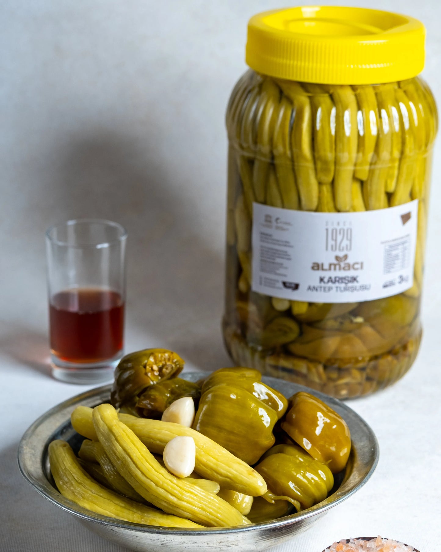 Almacı Pazarı 3kg karışık turşu bidonu ve sunum tabağı; içinde sadece acur ve biber bulunan, sarımsaklı ve sirkeli geleneksel Antep turşusu.