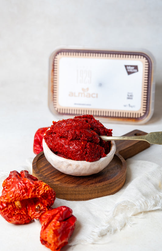 Yakından görünüm kasede acı biber salçası, güneşte suyunu çekmiş koyu kıvamlı ve pütürlü doğal dokusuyla Antep usulü ev salçası.