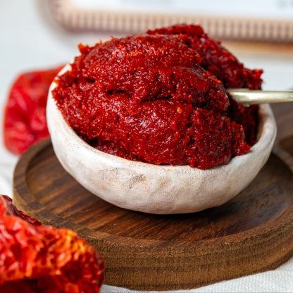 Yakından görünüm kasede acı biber salçası, güneşte suyunu çekmiş koyu kıvamlı ve pütürlü doğal dokusuyla Antep usulü ev salçası.