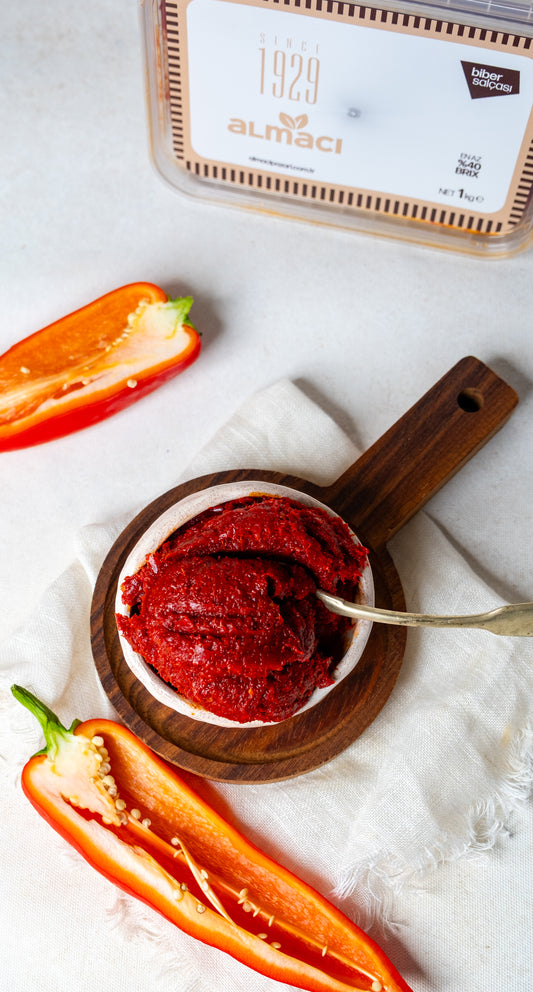 Kaşıkta tatlı biber salçası, taze kapya biberlerden üretilen, acısız ve koyu kıvamlı Antep usulü güneşte kurutulmuş salça.