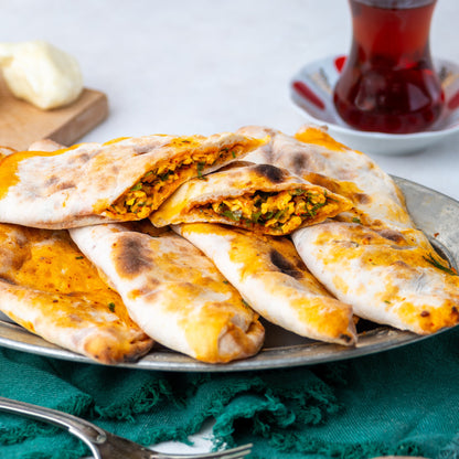 İkiye bölünmüş peynirli börek, içinde maydanoz, pul biber ve yumurta ile harmanlanmış özel peynir harcı bulunan, taş fırın pidesi.