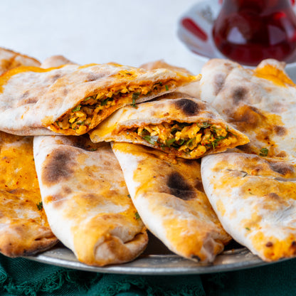 İkiye bölünmüş peynirli börek, içinde maydanoz, pul biber ve yumurta ile harmanlanmış özel peynir harcı bulunan, taş fırın pidesi.