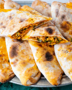 İkiye bölünmüş peynirli börek, içinde maydanoz, pul biber ve yumurta ile harmanlanmış özel peynir harcı bulunan, taş fırın pidesi.