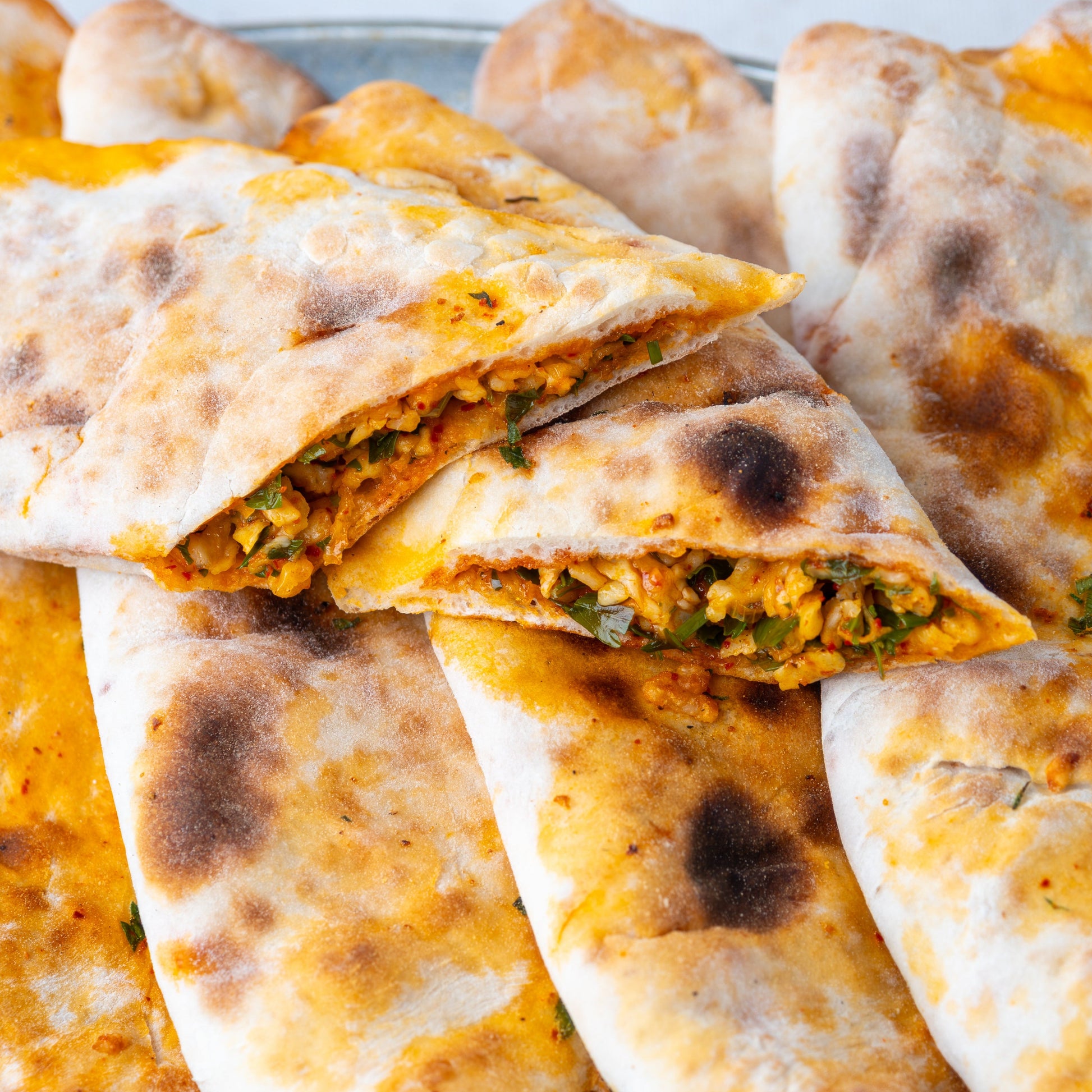 İkiye bölünmüş peynirli börek, içinde maydanoz, pul biber ve yumurta ile harmanlanmış özel peynir harcı bulunan, taş fırın pidesi.