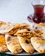 İkiye bölünmüş peynirli börek, içinde maydanoz, pul biber ve yumurta ile harmanlanmış özel peynir harcı bulunan, taş fırın pidesi.