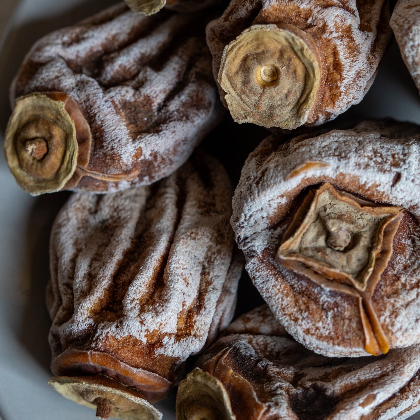 Yakından görünüm kuru cennet hurması, üzerindeki beyaz doğal şeker tabakasıyla (mannitol) bilinen lokum kıvamında Trabzon hurması.