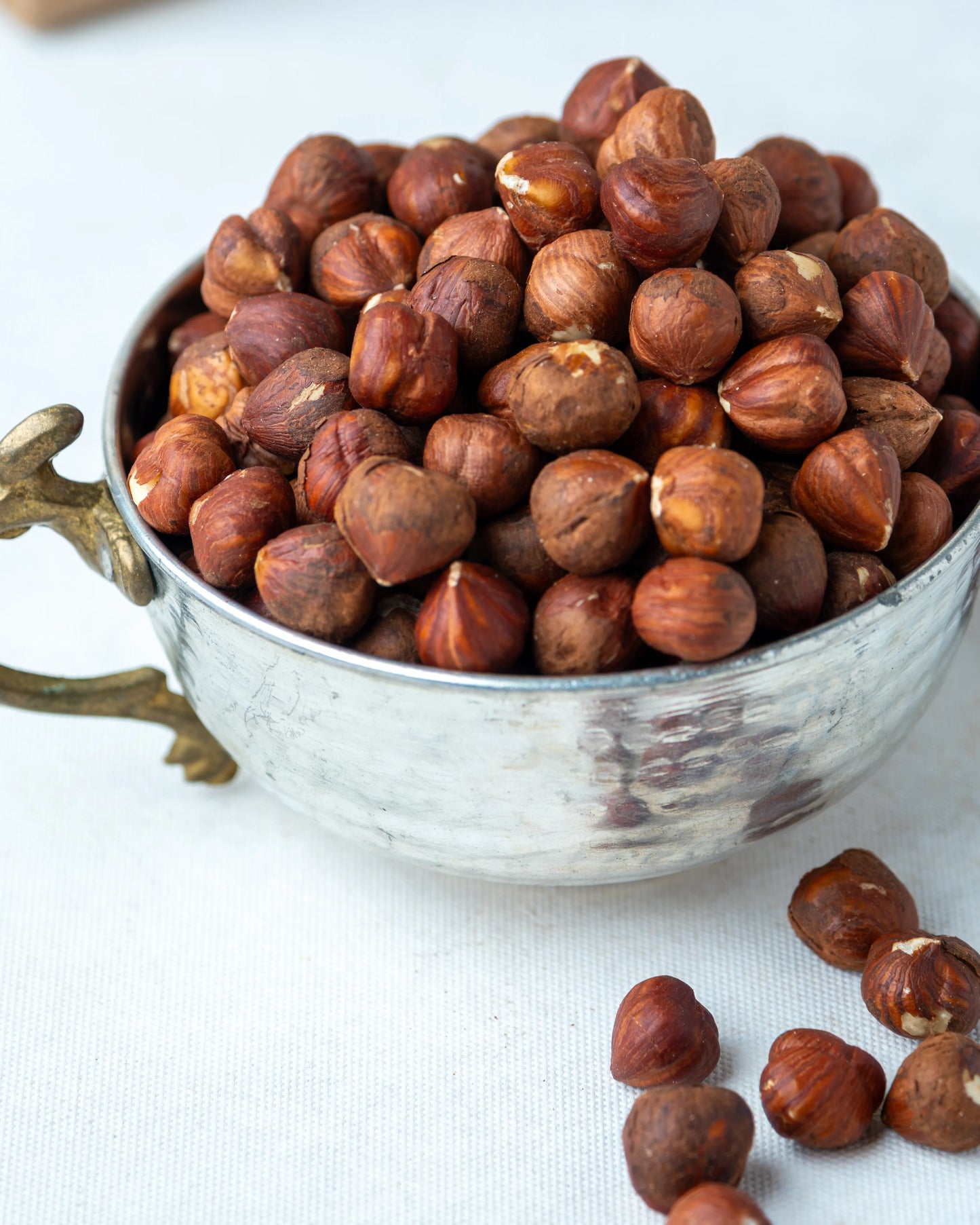 Metal kasede sunulan çiğ fındık içi ve arkada Almacı Pazarı paketi, kavrulmamış ve tuzsuz, yüksek yağ oranlı Giresun kalite doğal kuruyemiş.