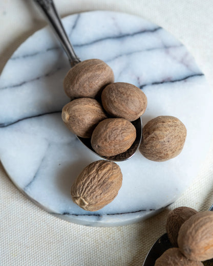 Tane muskat yakından görünüm, sert dokusu ve yoğun aromasıyla beşamel soslar için ideal taze muskat cevizi detayı.