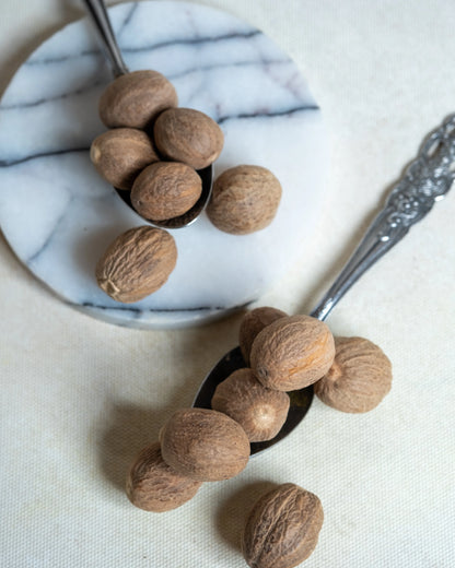 Tane muskat yakından görünüm, sert dokusu ve yoğun aromasıyla beşamel soslar için ideal taze muskat cevizi detayı.