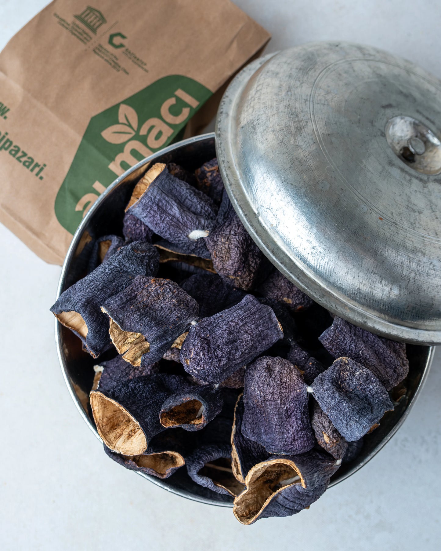 Metal kasede sunulan kuru patlıcanlar ve Almacı Pazarı kesekağıdı, güneşte kurutulmuş, içi oyulmuş ve ince kabuklu doğal Antep dolmalığı.