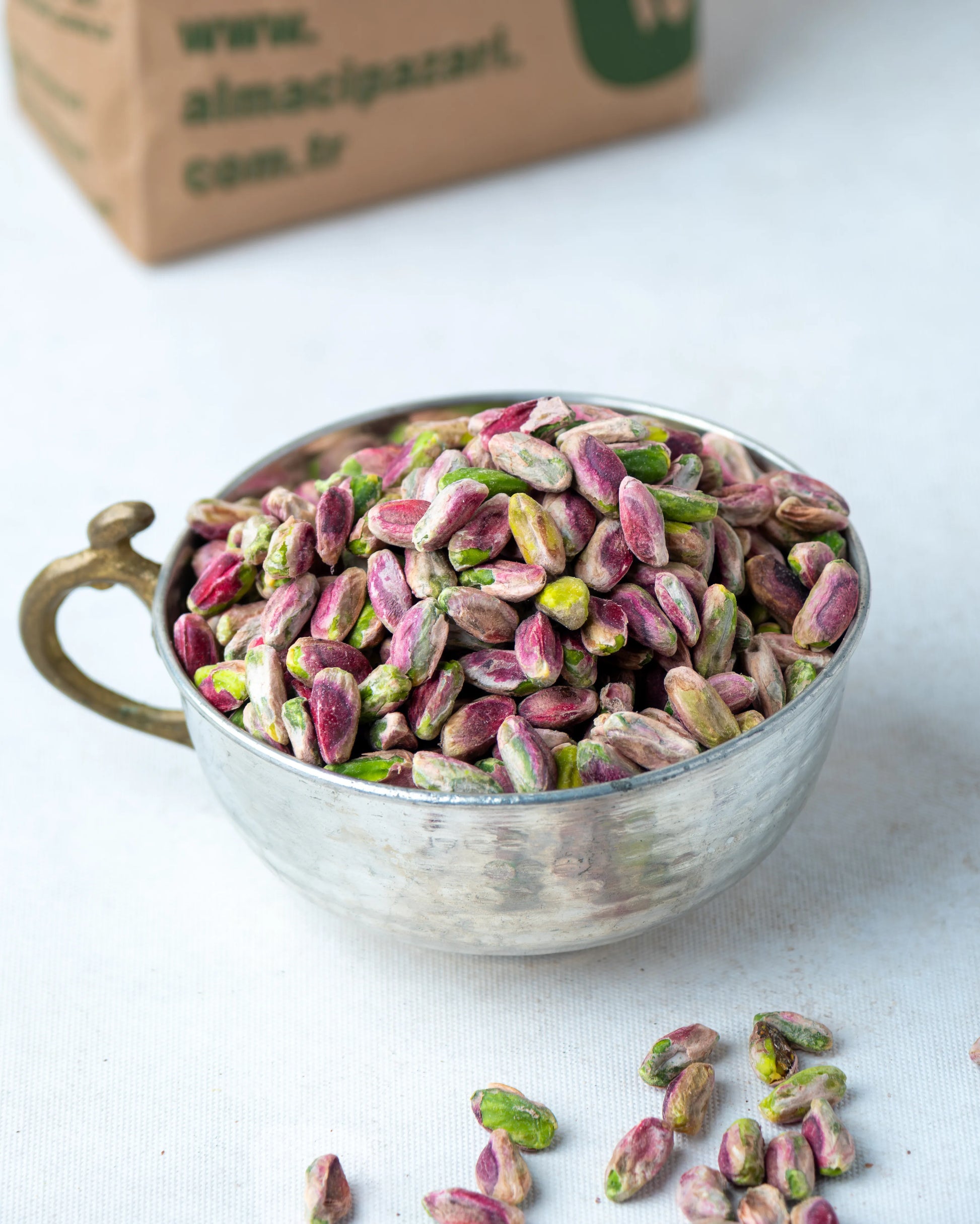 Yakından görünüm kırmızı iç Antep fıstığı, pembe zarlı ve yeşil içli tam olgunlaşmış ayıklanmış kuruyemiş taneleri.