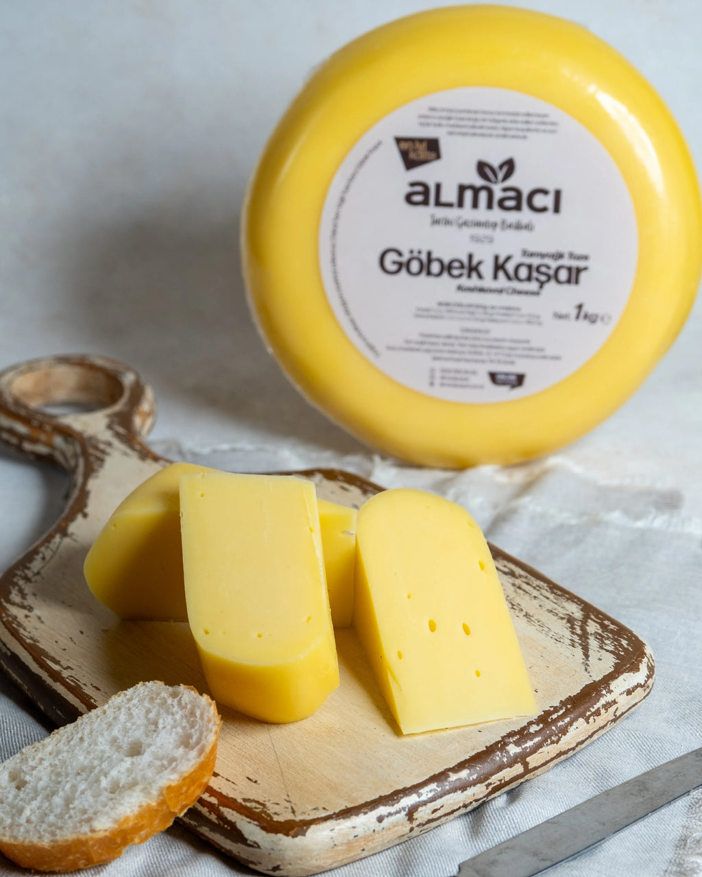 Almacı Pazarı yuvarlak göbek kaşar peyniri ve dilimleri, tam yağlı süt içeriğiyle tostlarda mükemmel eriyen taze kaşar.