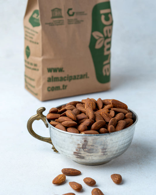 Yakından görünüm kavrulmuş badem içi, tuza bulanmış koyu renkli ve çizgili yüzeyiyle bilinen, gevrek ve tuzlu lüks kuruyemiş.