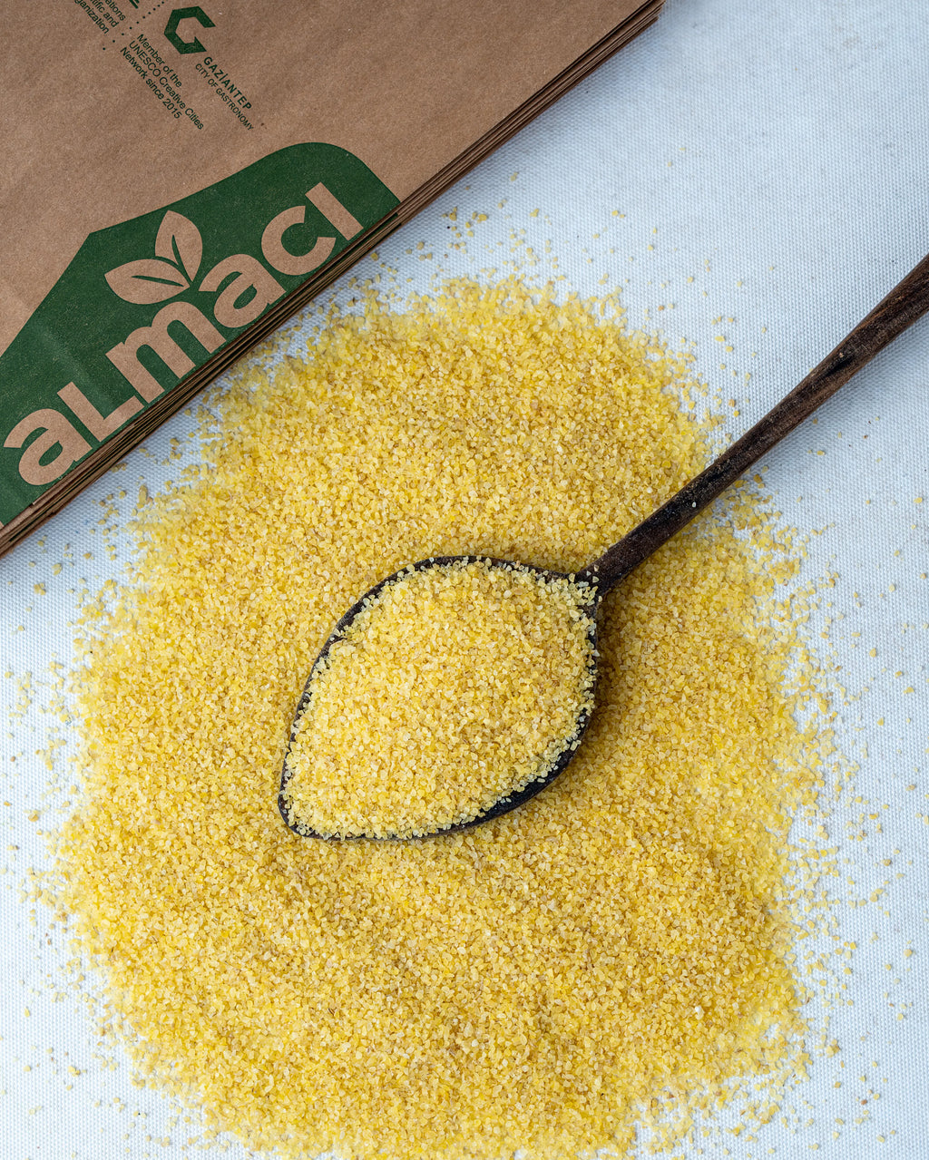 Yakından görünüm tahta kaşıkta ince bulgur (Simit), kısır ve mercimek köftesi yapımı için kullanılan altın sarısı köftelik bulgur.