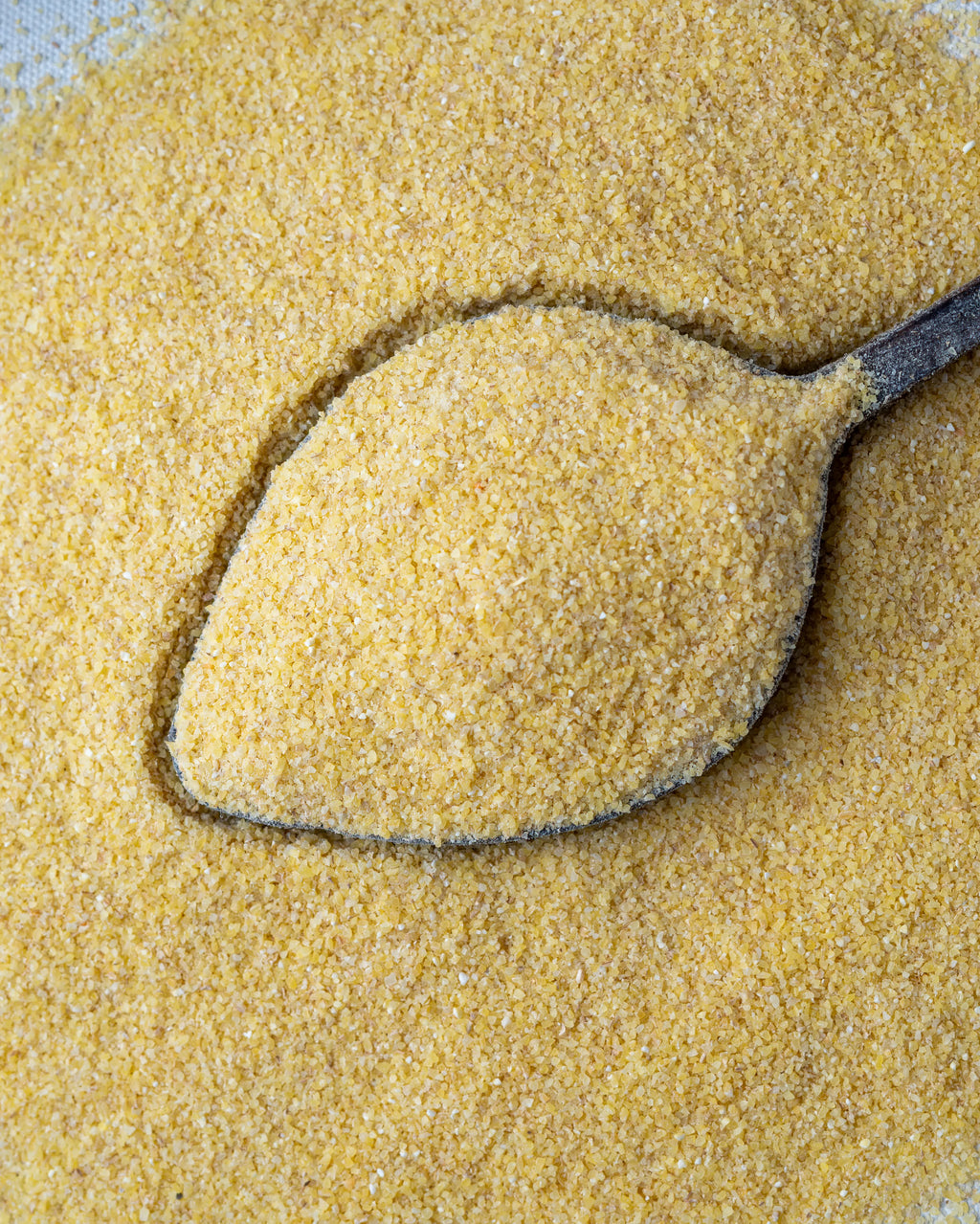 Yakından görünüm tahta kaşıkta ince bulgur (Simit), kısır ve mercimek köftesi yapımı için kullanılan altın sarısı köftelik bulgur.