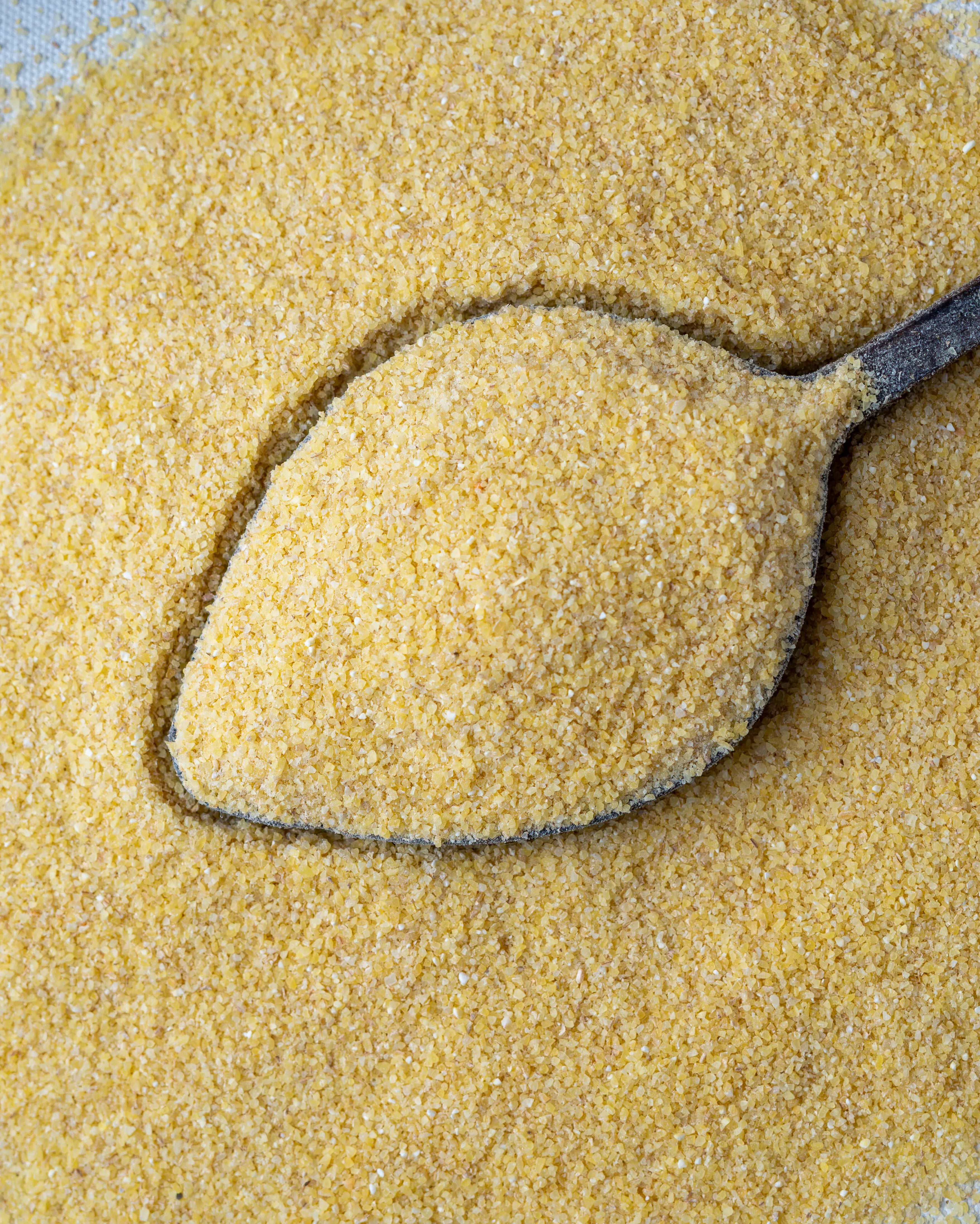 Yakından görünüm tahta kaşıkta ince bulgur (Simit), kısır ve mercimek köftesi yapımı için kullanılan altın sarısı köftelik bulgur.