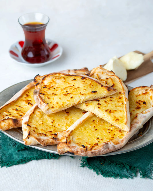 Yakından görünüm dilimlenmiş şekerli börek, erimiş tuzsuz Antep peyniri ve şekerle hazırlanan, taş fırında pişmiş sıcak tatlı pide.