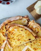Yakından görünüm dilimlenmiş şekerli börek, erimiş tuzsuz Antep peyniri ve şekerle hazırlanan, taş fırında pişmiş sıcak tatlı pide.