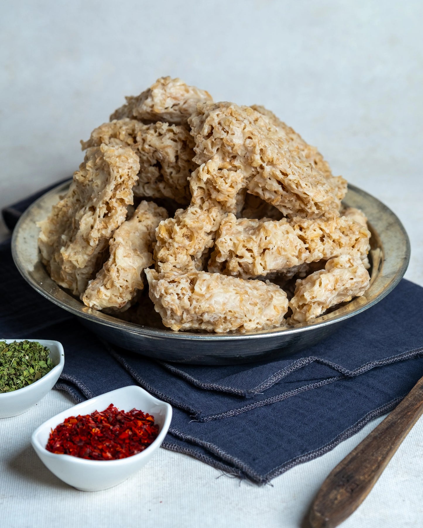 Metal tabakta sunulan sıkma tarhana, yanında kuru nane ve pul biber ile çerez gibi tüketilen, yoğurtlu doğal probiyotik atıştırmalık.