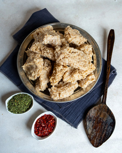 Metal tabakta sunulan sıkma tarhana, yanında kuru nane ve pul biber ile çerez gibi tüketilen, yoğurtlu doğal probiyotik atıştırmalık.