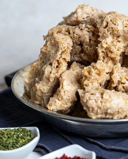 Metal tabakta sunulan sıkma tarhana, yanında kuru nane ve pul biber ile çerez gibi tüketilen, yoğurtlu doğal probiyotik atıştırmalık.