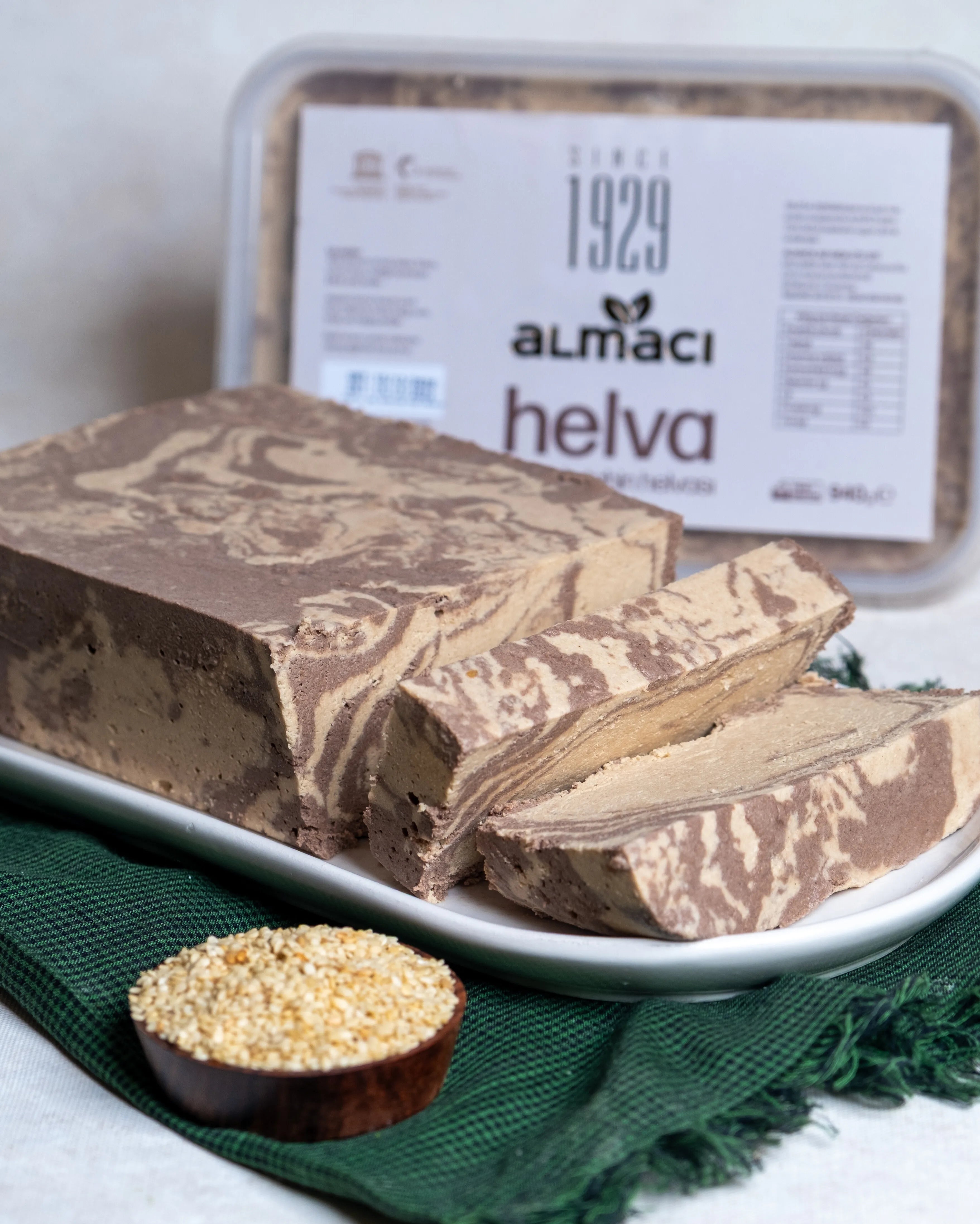 Ahşap sunumda dilimlenmiş kakaolu tahin helvası, sade ve kakaolu karışımın oluşturduğu mermer desenli geleneksel kahvaltılık tatlı.
