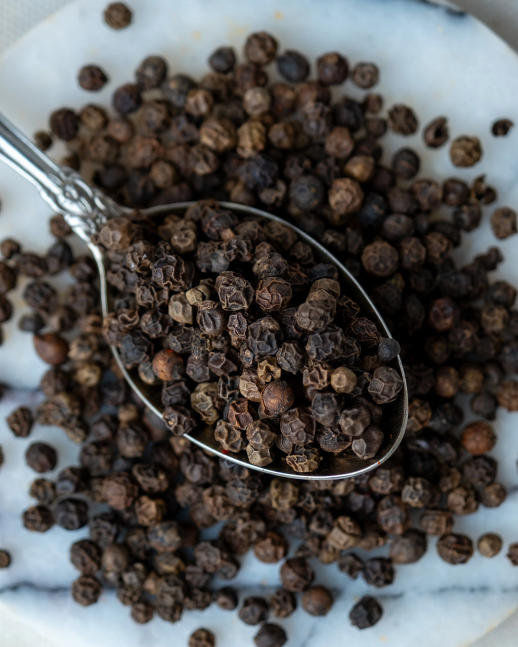 Paketli tane karabiber sunumu, sofrada taze öğütülerek kullanılan aromatik ve keskin siyah biber tohumları.