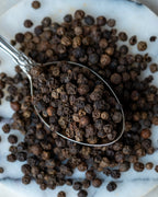 Paketli tane karabiber sunumu, sofrada taze öğütülerek kullanılan aromatik ve keskin siyah biber tohumları.