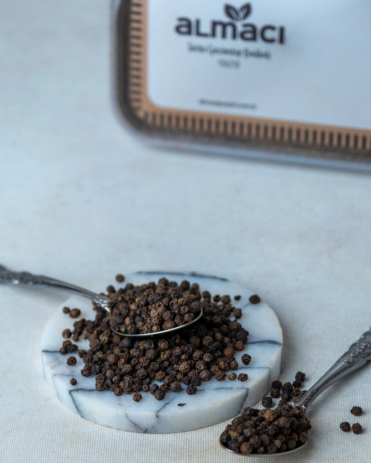 Paketli tane karabiber sunumu, sofrada taze öğütülerek kullanılan aromatik ve keskin siyah biber tohumları.