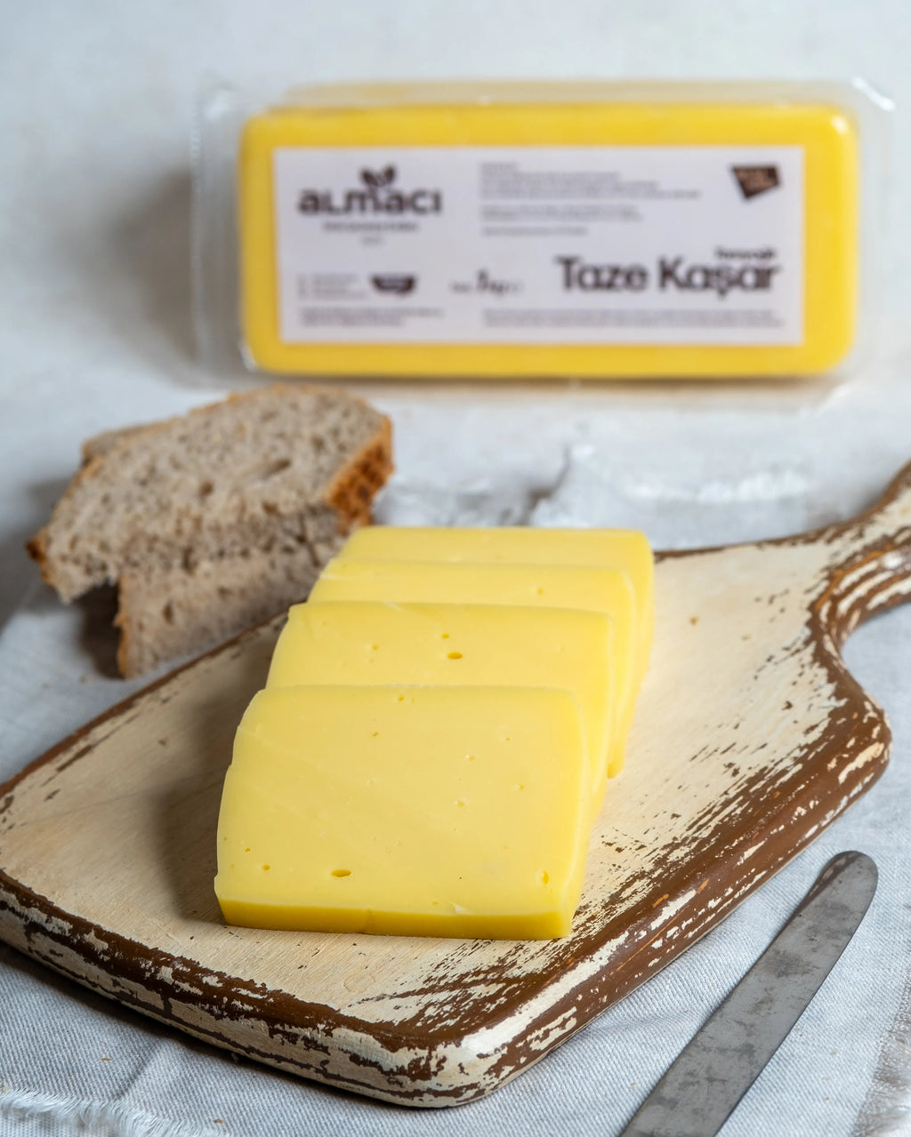 Paketli Almacı Pazarı 1 kg taze kaşar peyniri, tam yağlı inek sütünden üretilen, tost ve pizzalar için ideal eriyen blok peynir.