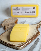 Paketli Almacı Pazarı 1 kg taze kaşar peyniri, tam yağlı inek sütünden üretilen, tost ve pizzalar için ideal eriyen blok peynir.