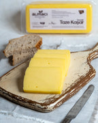 Paketli Almacı Pazarı 1 kg taze kaşar peyniri, tam yağlı inek sütünden üretilen, tost ve pizzalar için ideal eriyen blok peynir.
