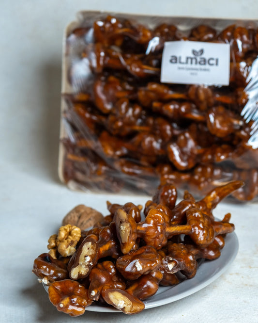 Paketli cevizli sucuk sunumu, hakiki üzüm şırasına batırılmış ipe dizili bütün cevizli geleneksel tatlı.