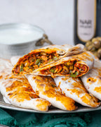İkiye bölünmüş zeytinli börek, içinde dilimlenmiş yeşil zeytin, ceviz ve nar ekşili özel harç bulunan, taş fırında pişmiş Gaziantep kahvaltılığı.