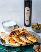İkiye bölünmüş zeytinli börek, içinde dilimlenmiş yeşil zeytin, ceviz ve nar ekşili özel harç bulunan, taş fırında pişmiş Gaziantep kahvaltılığı.