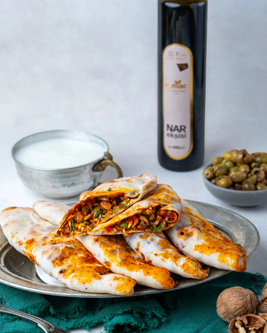 İkiye bölünmüş zeytinli börek, içinde dilimlenmiş yeşil zeytin, ceviz ve nar ekşili özel harç bulunan, taş fırında pişmiş Gaziantep kahvaltılığı.